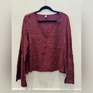 BP burgundy blouse w/ v-neckline and long, ruffled bell sleeves.